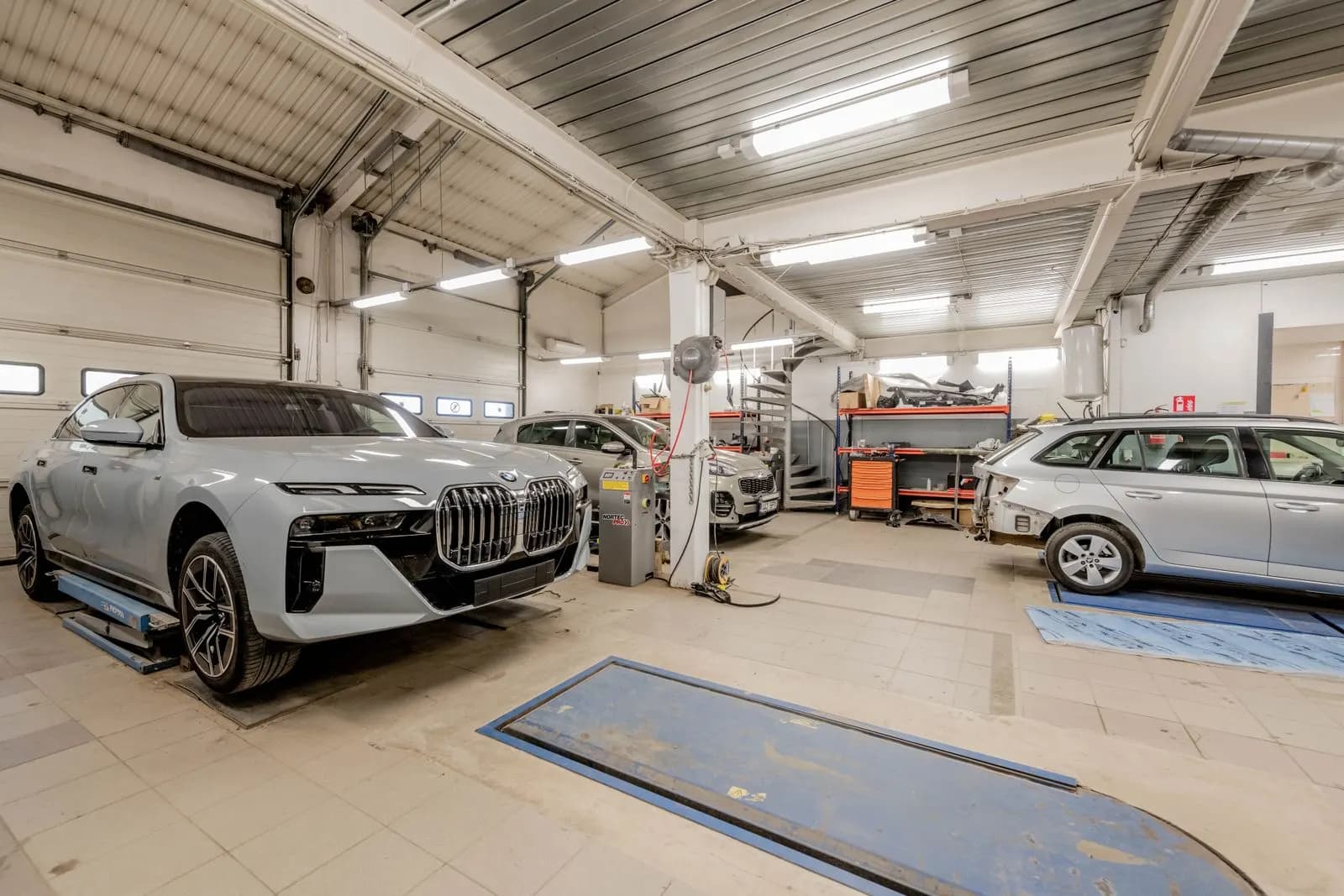 Aydınlık bir oto servis atölyesinde bakım bekleyen araçlar