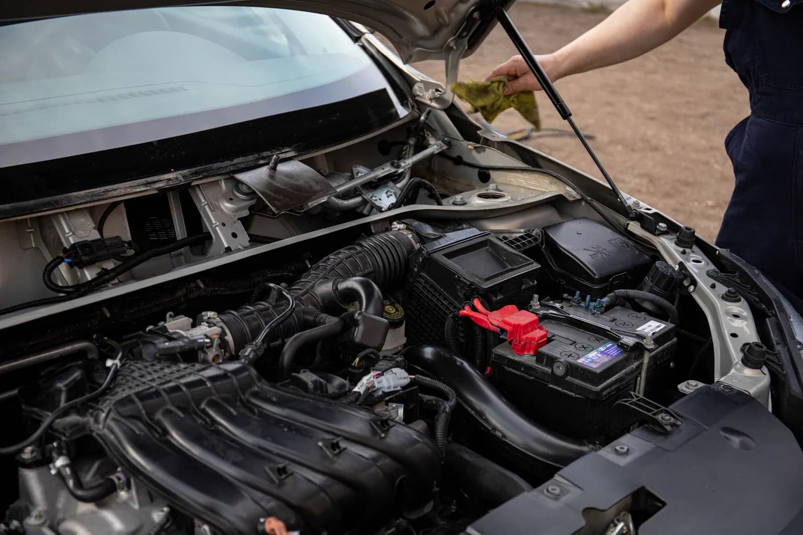 Açık kaput altında motor bölmesi ve akü