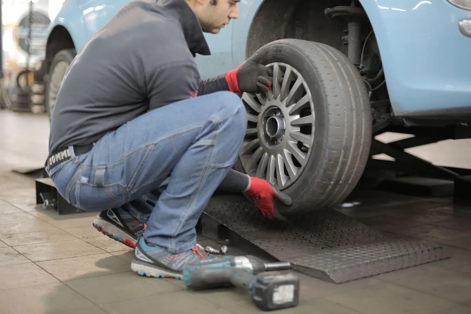 Lastik servisinde araç lastiğini değiştiren usta