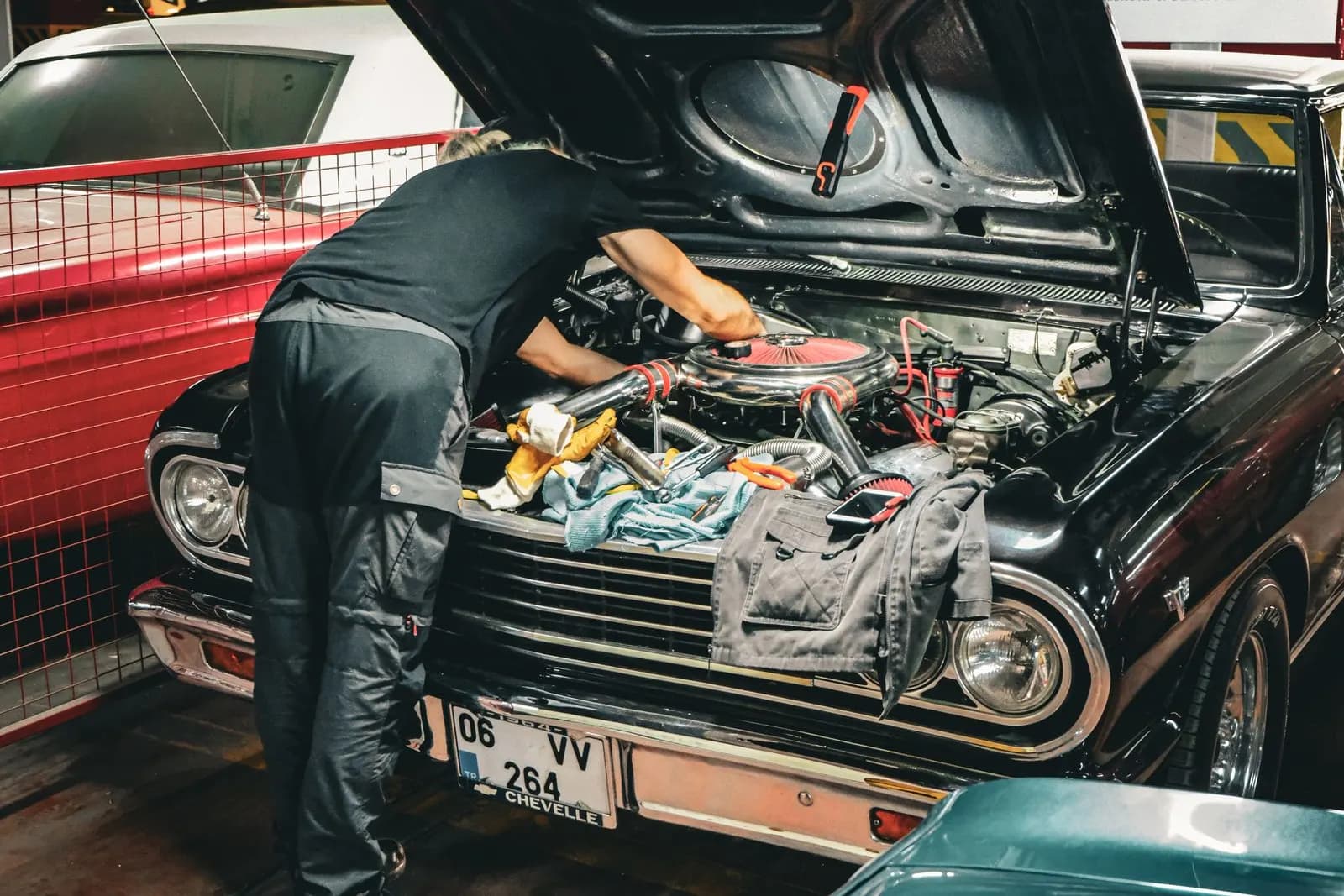Ustanın kaputu açık klasik bir aracın motoruyla ilgilenmesi